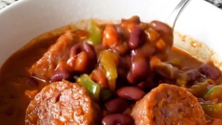 A hearty bowl of bratwurst chili with beans and peppers, steaming hot and ready to eat.