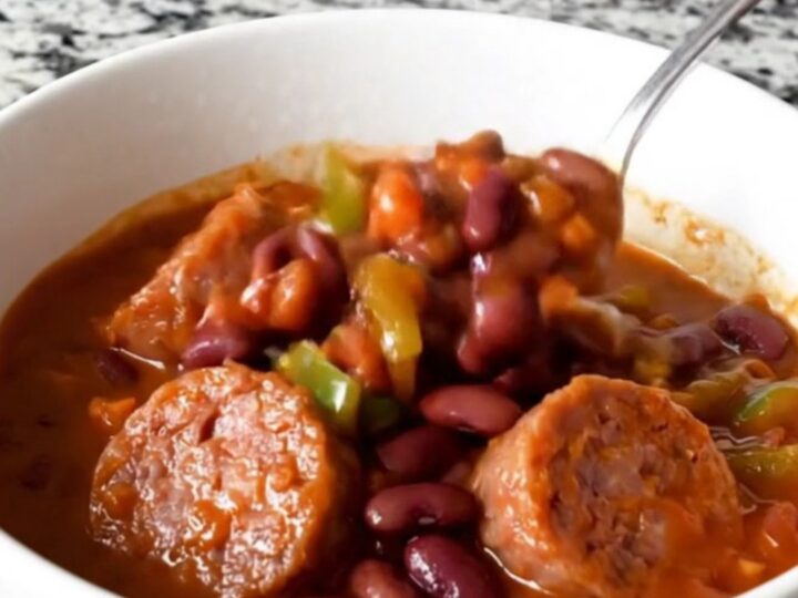 A hearty bowl of bratwurst chili with beans and peppers, steaming hot and ready to eat.