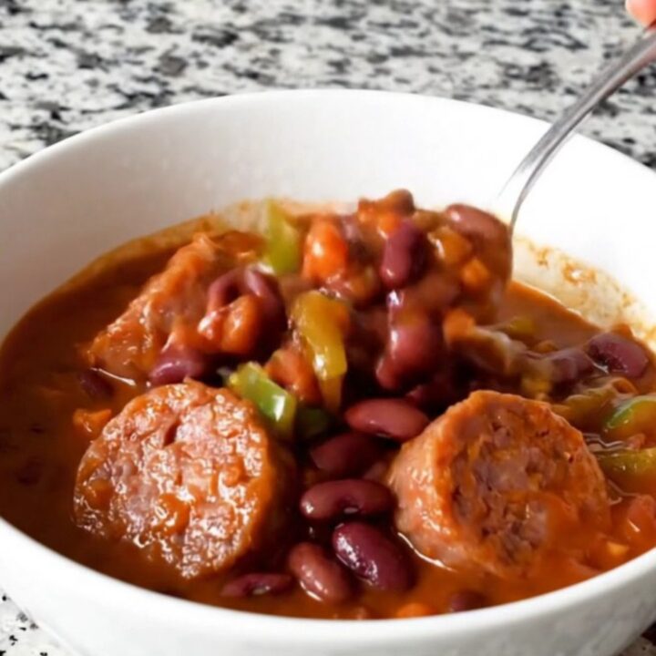 A hearty bowl of bratwurst chili with beans and peppers, steaming hot and ready to eat.