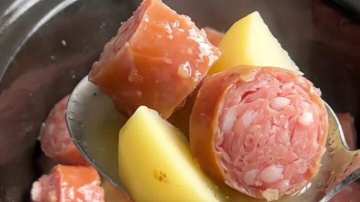 A close-up view of the slow cooker filled with golden potatoes and savory Italian sausage in a light lemony broth.