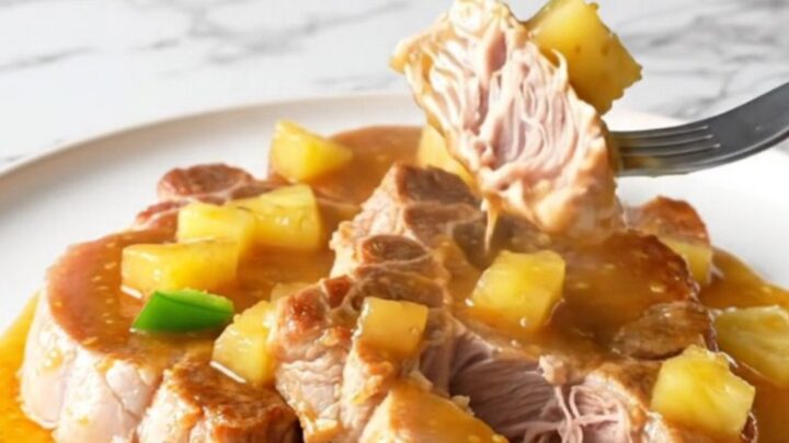 Bone-in pork shoulder steaks in a slow cooker with pineapple chunks and peppers.