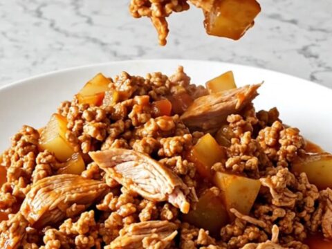 A hearty bowl of slow cooker ranchero ground turkey with potatoes and colorful bell peppers in a red sauce.