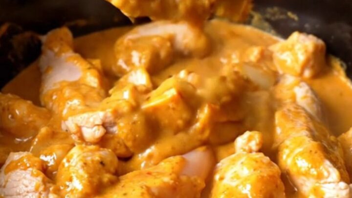 A close-up view of creamy buffalo chicken tenders and potatoes in a black slow cooker insert.