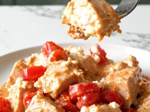 A plate of Utica-style chicken with creamy tomato sauce and cherry peppers.