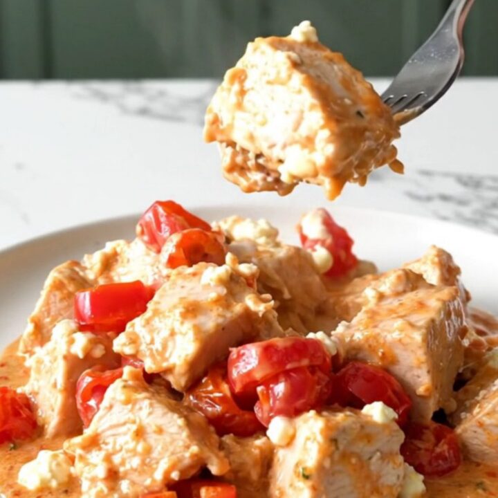 A plate of Utica-style chicken with creamy tomato sauce and cherry peppers.