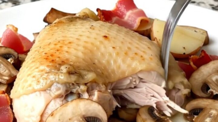 Slow cooker chicken thighs with bacon, mushrooms, and potatoes in a black stoneware insert.