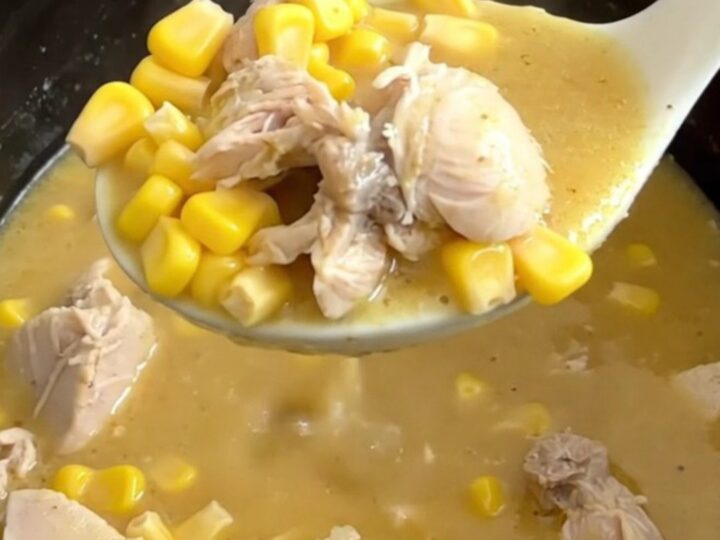 A close-up of a bowl of creamy chicken and sweet corn soup with visible chicken chunks and corn kernels.