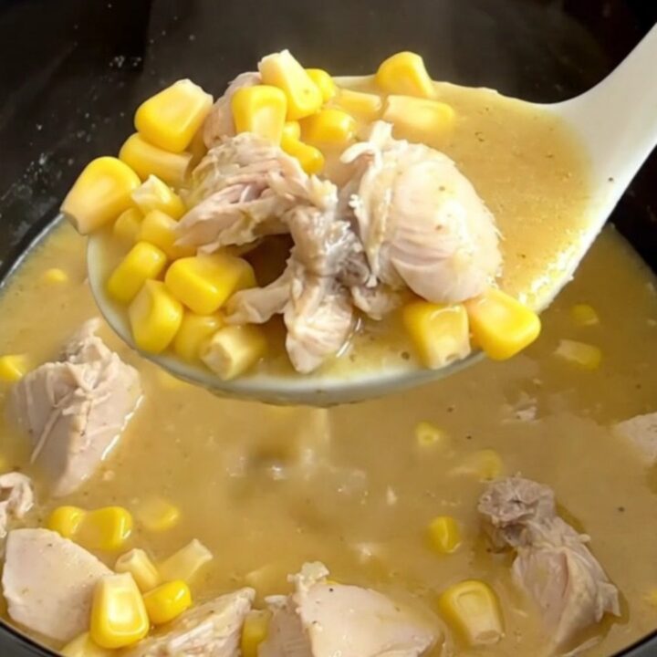 A close-up of a bowl of creamy chicken and sweet corn soup with visible chicken chunks and corn kernels.
