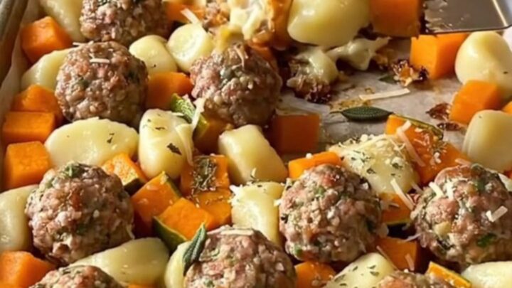 A sheet pan filled with golden roasted gnocchi, turkey meatballs, and butternut squash cubes.