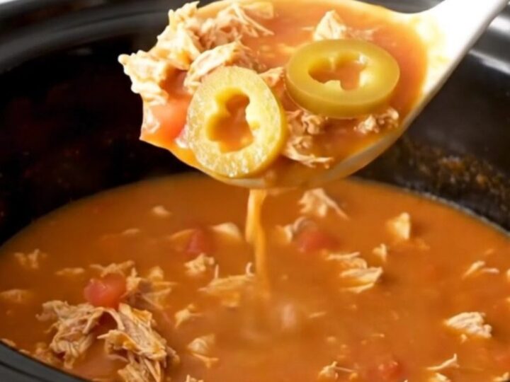 A close-up of creamy tomato-based grinder soup with ground turkey and pepperoncini in a slow cooker.