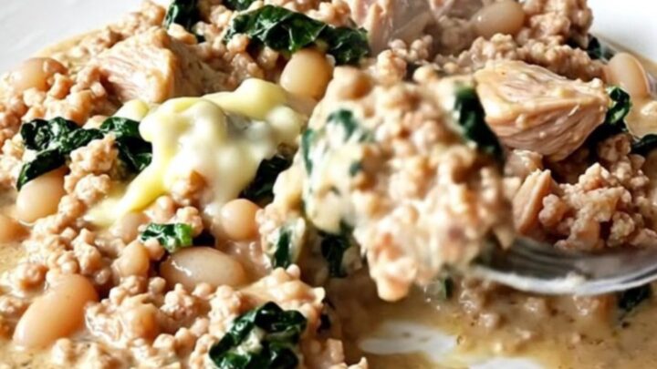 A close-up of creamy Tuscan ground turkey with white beans and spinach in a slow cooker.