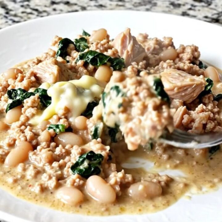A close-up of creamy Tuscan ground turkey with white beans and spinach in a slow cooker.