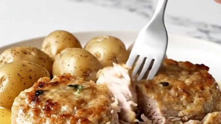 A close-up of golden-tan turkey burger steaks with tender baby potatoes in a savory brown butter sauce.