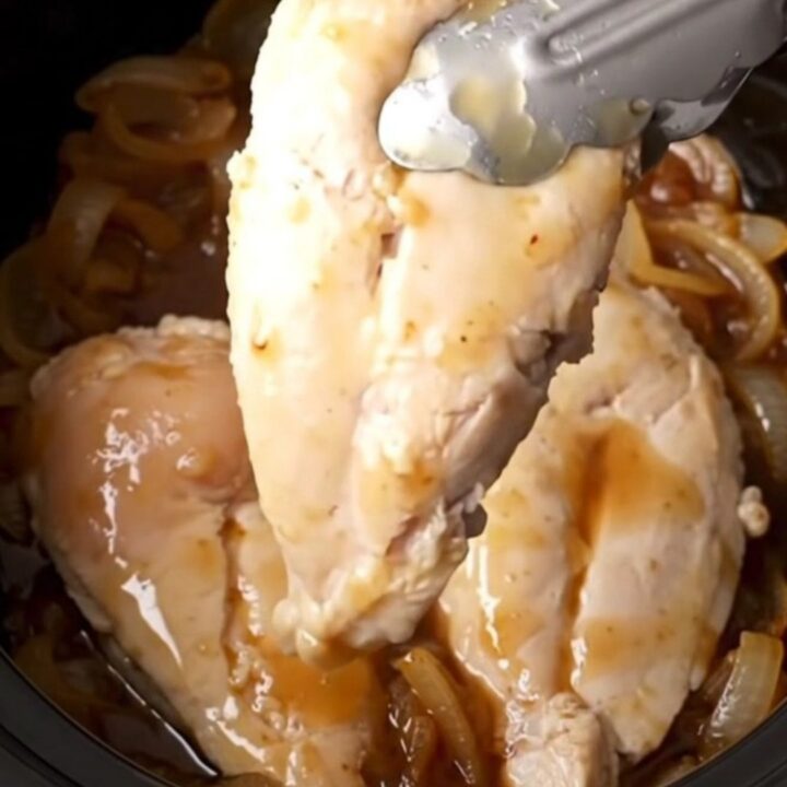 A close-up of tender, golden-tan chicken breasts coated in a thick