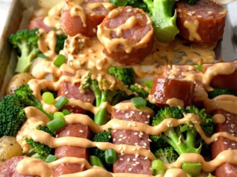 A sheet pan filled with golden-brown kielbasa, roasted baby potatoes