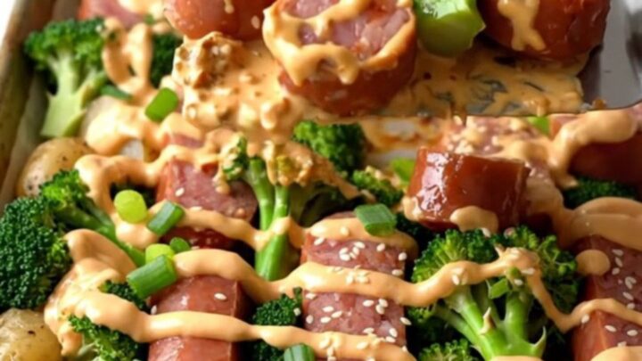 A sheet pan filled with golden-brown kielbasa, roasted baby potatoes