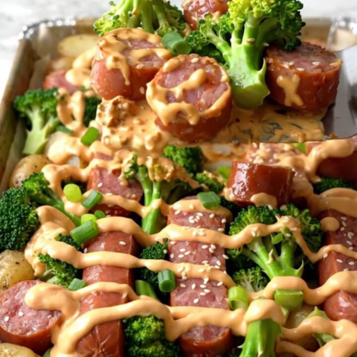 A sheet pan filled with golden-brown kielbasa, roasted baby potatoes
