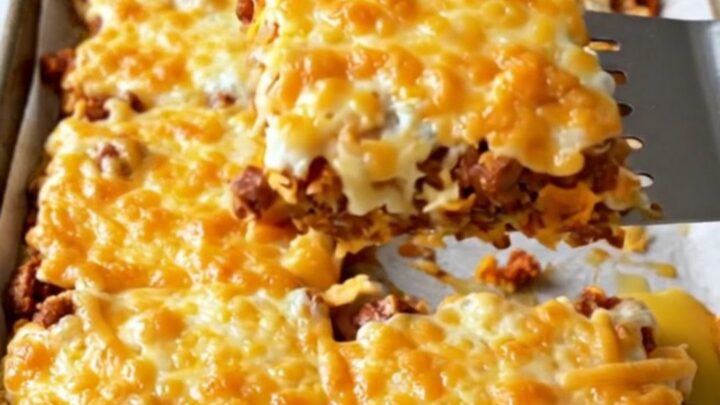 A top-down view of a sheet pan filled with chorizo, sweet potatoes, black beans