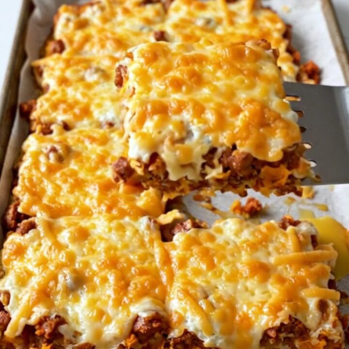 A top-down view of a sheet pan filled with chorizo, sweet potatoes, black beans