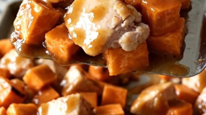 A sheet pan filled with golden roasted sweet potatoes, charred purple onions