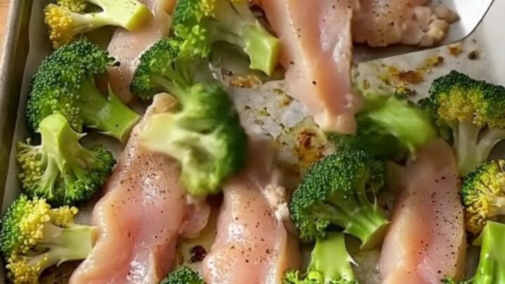 A sheet pan filled with golden-brown chicken tenders and roasted broccoli florets.