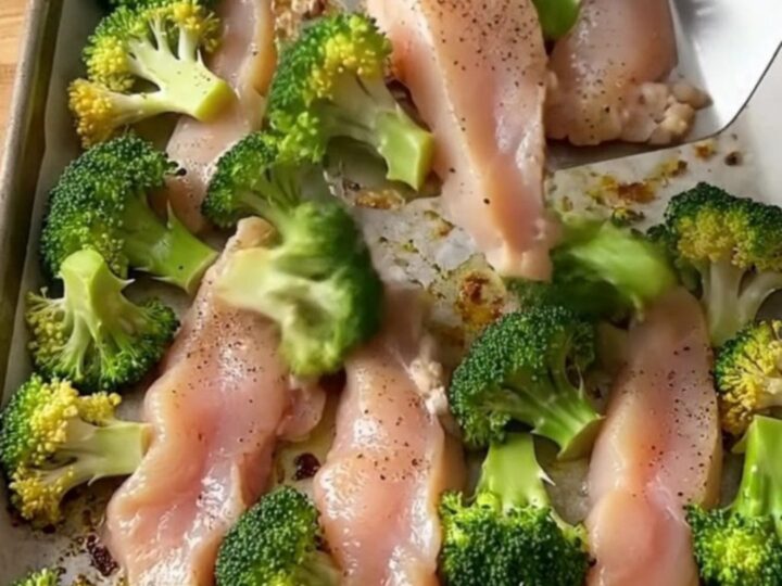 A sheet pan filled with golden-brown chicken tenders and roasted broccoli florets.