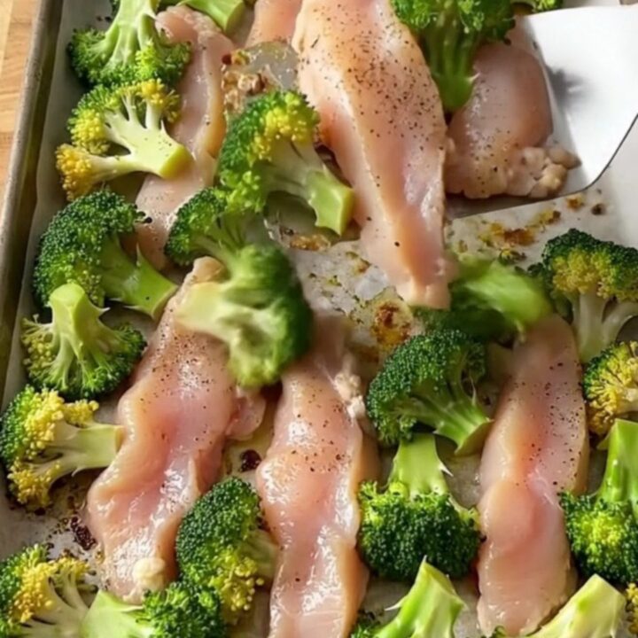 A sheet pan filled with golden-brown chicken tenders and roasted broccoli florets.