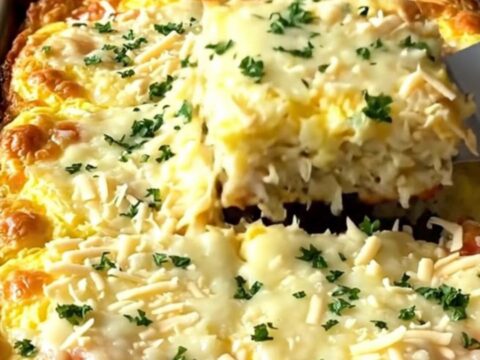 A sheet pan filled with a golden, baked egg casserole studded with turkey and stuffing.
