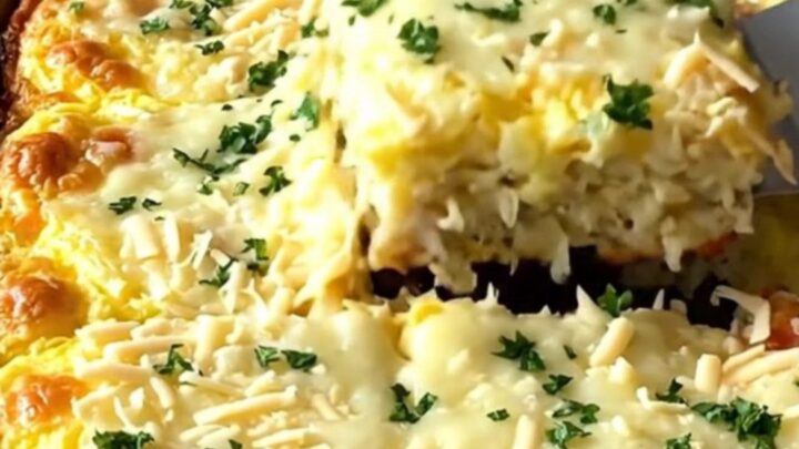 A sheet pan filled with a golden, baked egg casserole studded with turkey and stuffing.