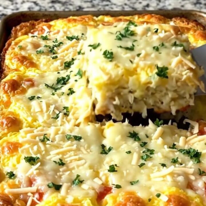 A sheet pan filled with a golden, baked egg casserole studded with turkey and stuffing.