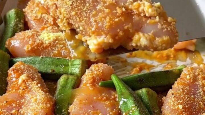 Crispy cornmeal crusted chicken tenders and roasted okra on a parchment-lined sheet pan.