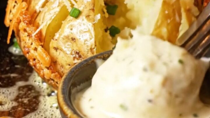 Close-up of a crispy Garlic Parmesan Hasselback Potato with golden ridges and melted cheese.