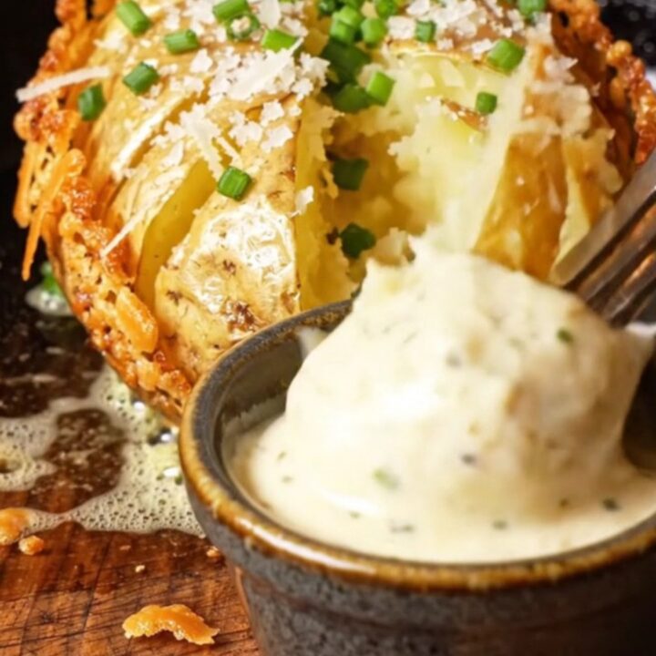 Close-up of a crispy Garlic Parmesan Hasselback Potato with golden ridges and melted cheese.