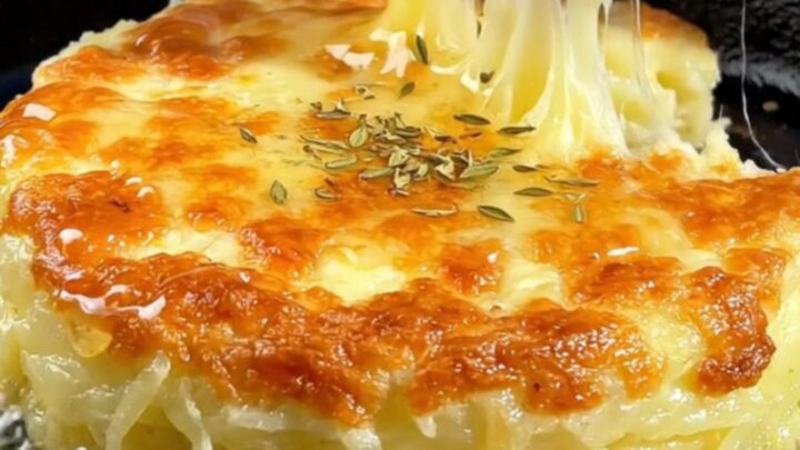 A crispy golden-brown potato and cheese cake in a cast-iron skillet, drizzled with honey and lemon.