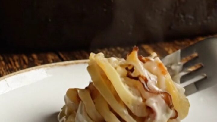 A close-up shot of a creamy potato and turnip gratin with a bubbly, blistered golden white cheddar crust.