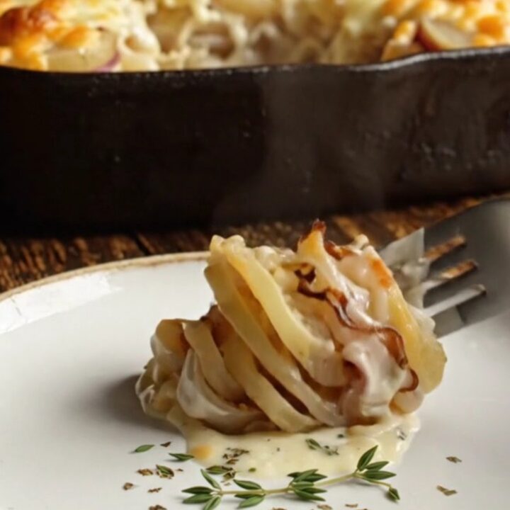 A close-up shot of a creamy potato and turnip gratin with a bubbly, blistered golden white cheddar crust.