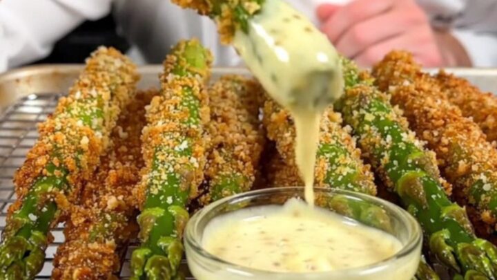 A close-up of crispy Parmesan-crusted asparagus spears on a wire rack, golden-brown and ready to serve.