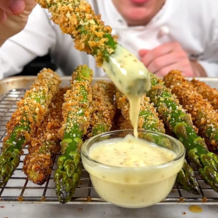 A close-up of crispy Parmesan-crusted asparagus spears on a wire rack, golden-brown and ready to serve.