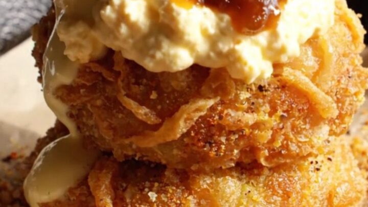A golden-brown fried green tomato topped with creamy pimento cheese and savory bacon jam.