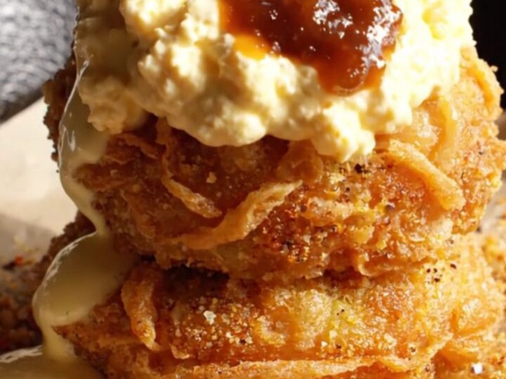 A golden-brown fried green tomato topped with creamy pimento cheese and savory bacon jam.
