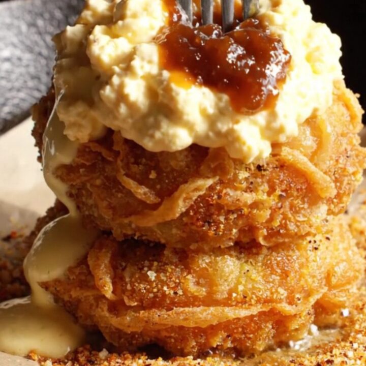 A golden-brown fried green tomato topped with creamy pimento cheese and savory bacon jam.