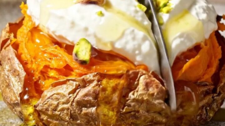 Crispy smashed sweet potato rounds topped with creamy whipped feta, hot honey, and crushed pistachios on a serving platter.