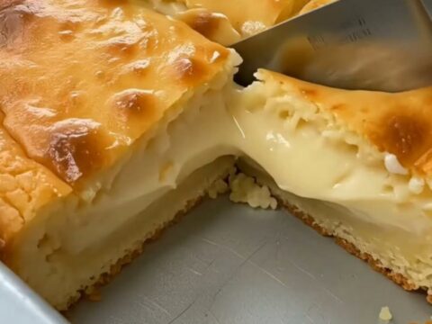 A golden square of baked cornmeal custard cake sliced to show a rich molten center.
