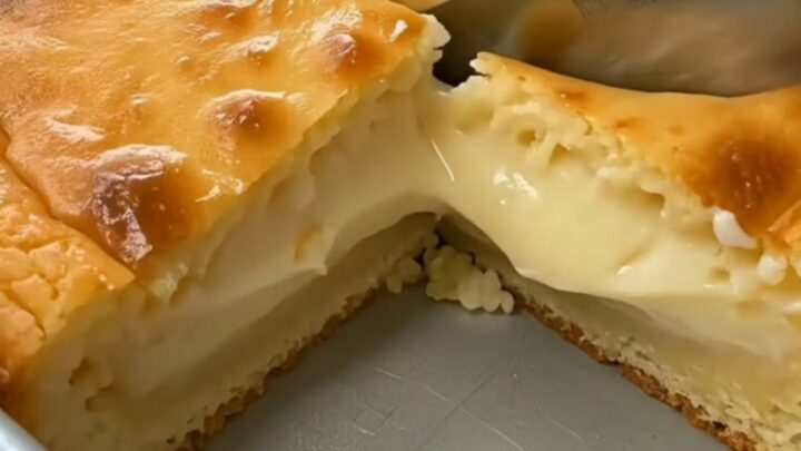 A golden square of baked cornmeal custard cake sliced to show a rich molten center.