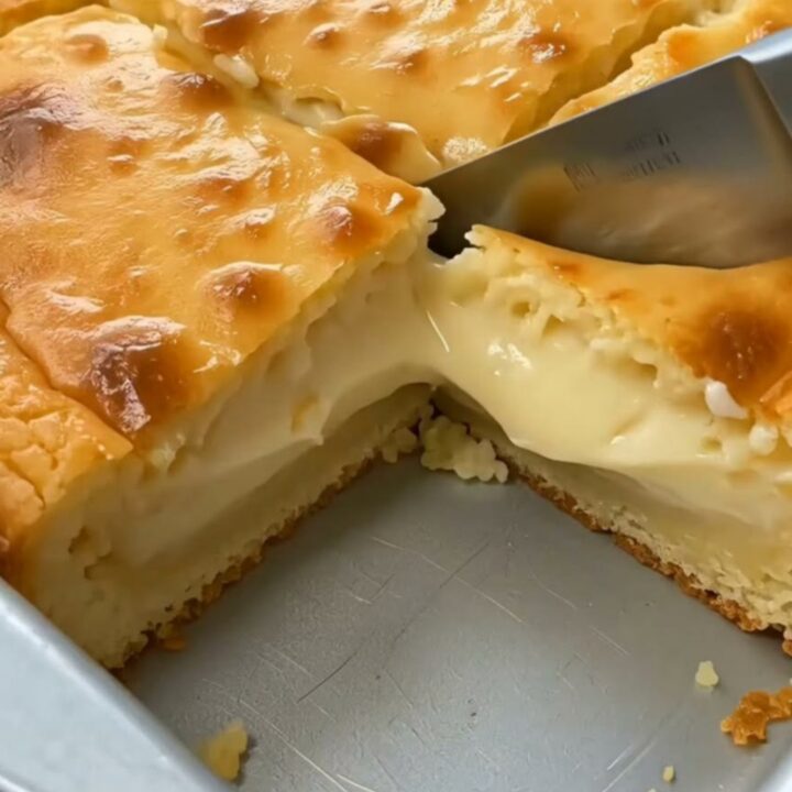 A golden square of baked cornmeal custard cake sliced to show a rich molten center.