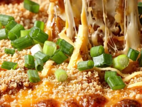 A cast-iron skillet filled with bubbly, golden-brown scalloped potatoes topped with a crispy panko crust.