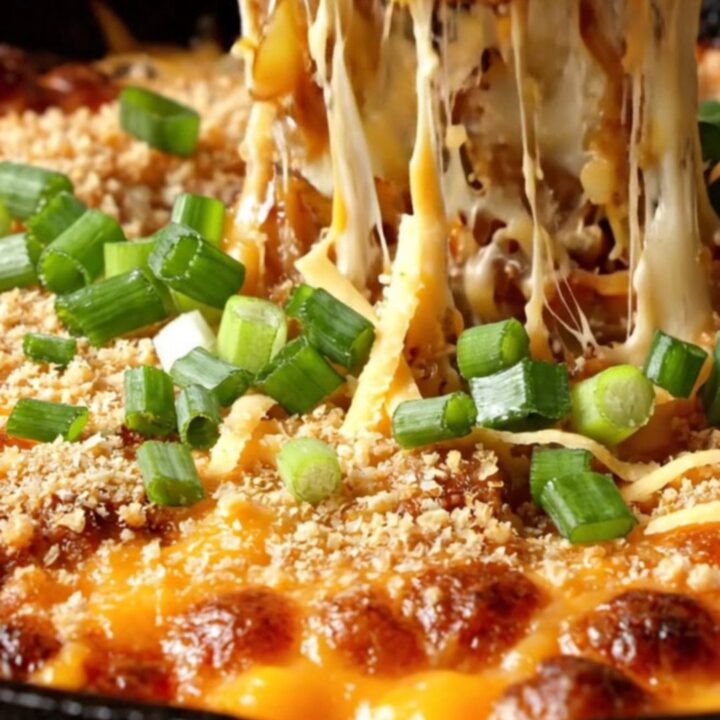 A cast-iron skillet filled with bubbly, golden-brown scalloped potatoes topped with a crispy panko crust.