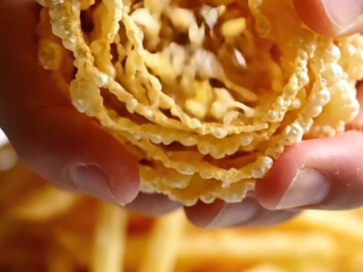 A mountain of golden, ultra-thin crispy potato and leek matchstick frites piled high on a dark plate.