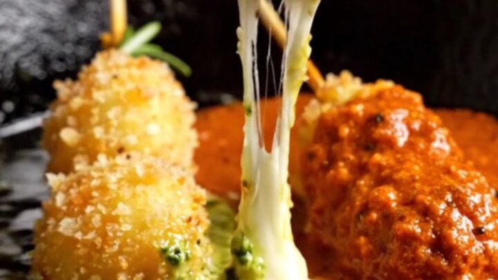 Golden-fried gnocchi skewers with a melted mozzarella core, served at a party.