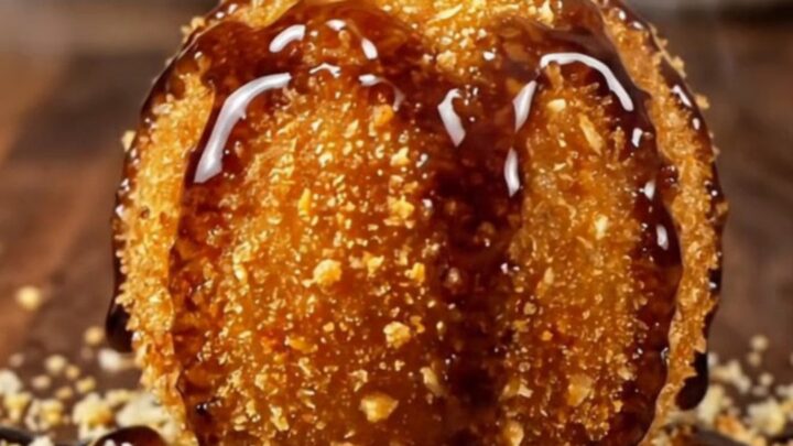 A golden-brown croquette broken open to show a creamy blue cheese and walnut center.